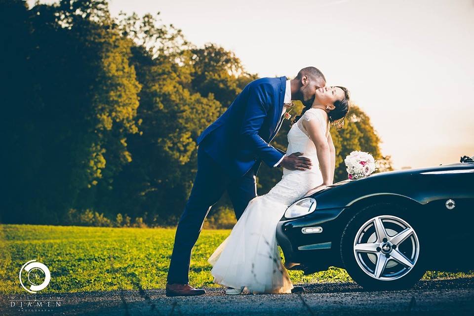 Mariage à l'heure dorée — les mariés s'embrassent devant une voiture de sport