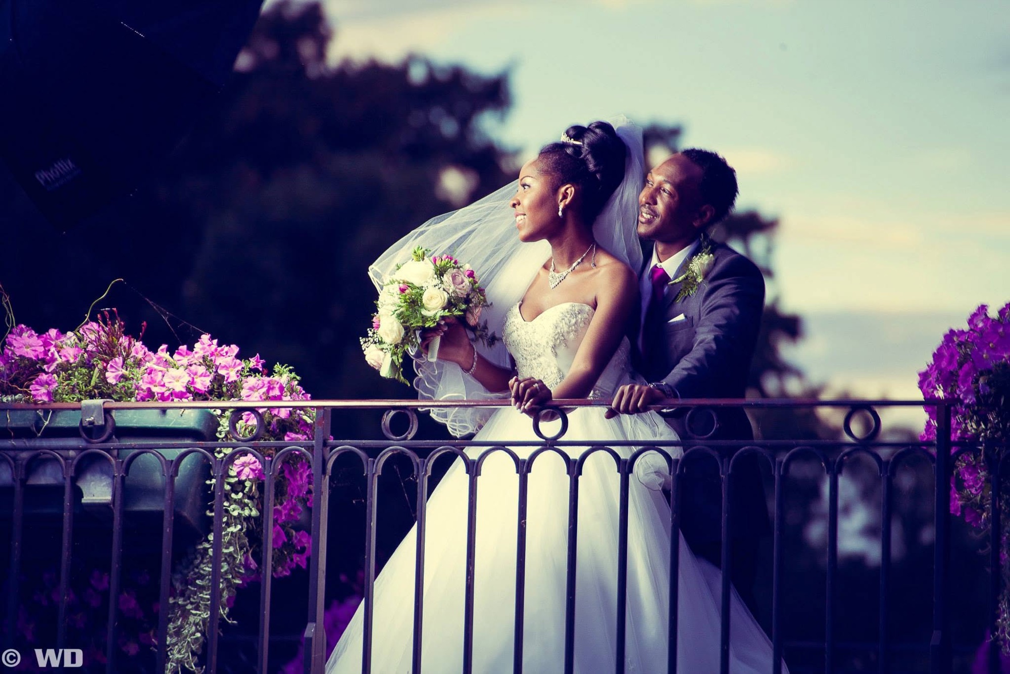 Couple de mariés sur un balcon fleuri au crépuscule